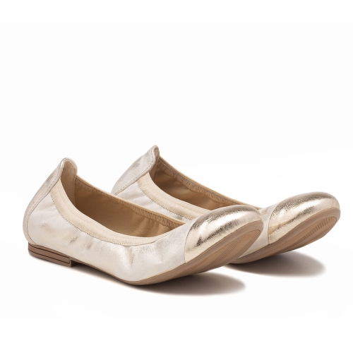 Złote skórzane baleriny. Bardzo miękkie obuwie damskie z ozdobnym złotym czubkiem. Baleriny na płaskiej podeszwie obszyte gumką. Widok z boku